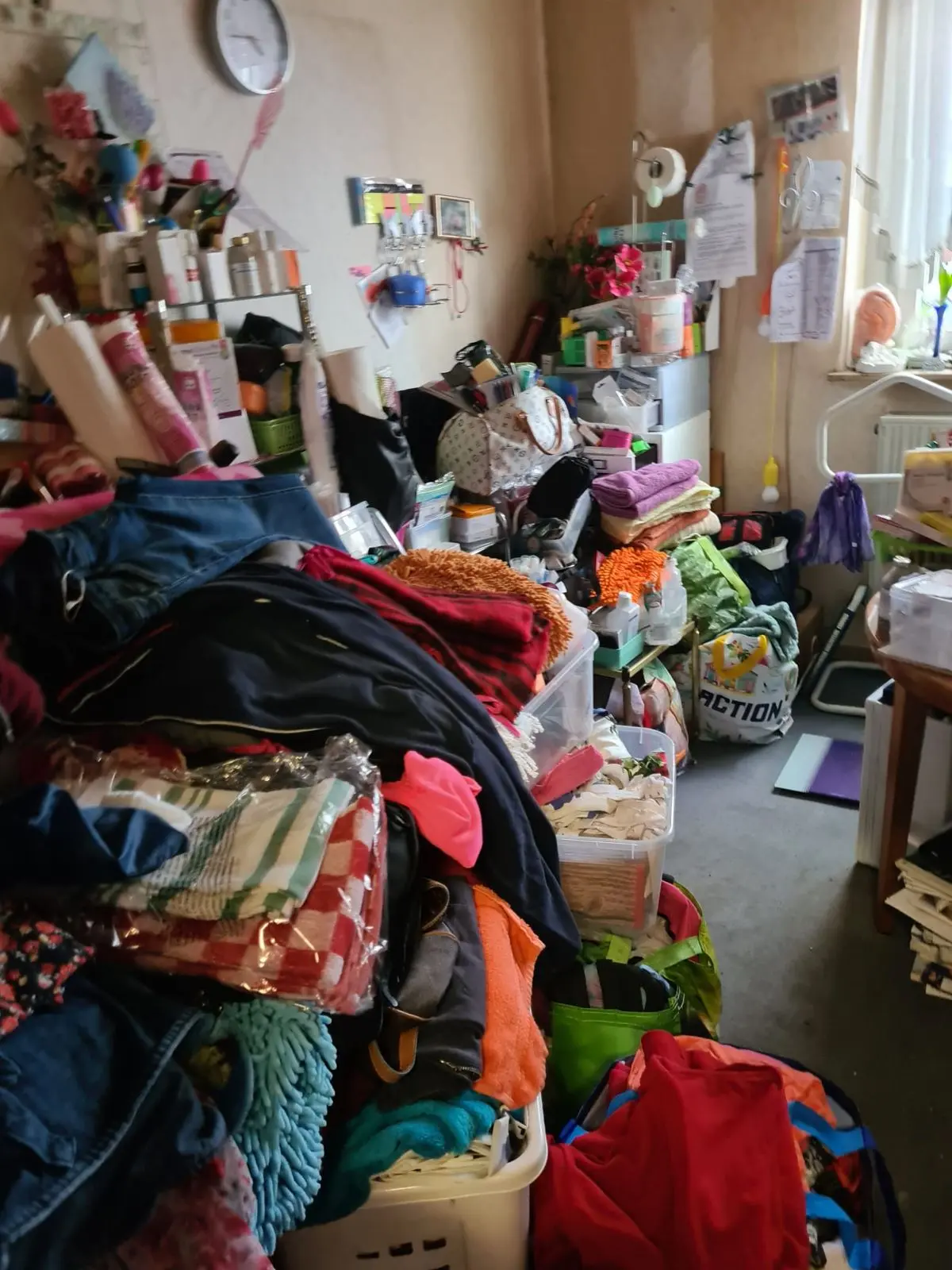 Kleidung und Kisten in einem Zimmer vor der Räumung
